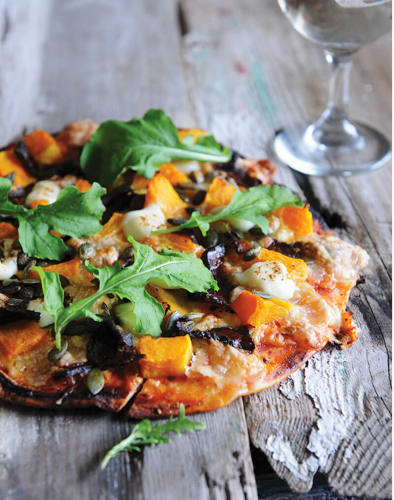 A pizza topped with pumpkin, biltong and rocket